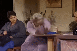 a woman in a purple dress is sitting at a table in a living room