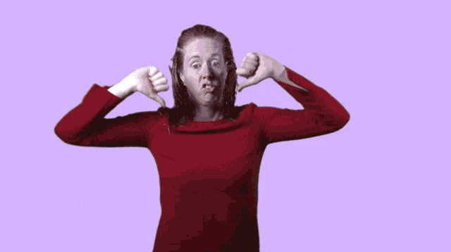 a woman in a red shirt is giving a thumbs down sign with the word boooo behind her