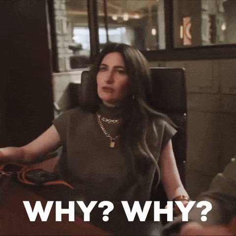 A woman seated at a restaurant asks “WHY? WHY?”