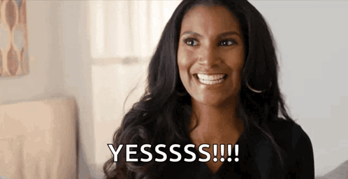 A woman smiles and claps while text says “YESSSS!!!!”
