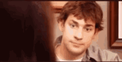 Jim Halpert gives a small embarrassed smile in a close-up.