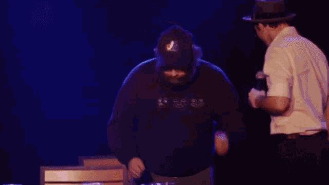 two men are dancing on a stage with the word party in blue letters