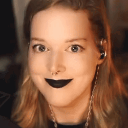 the woman is wearing black lipstick and a nose ring .