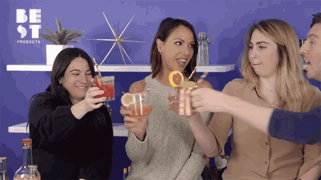 a group of people toasting with drinks in front of a be st products sign
