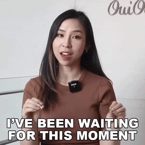 a woman is holding a rode microphone and saying i 've been waiting for this moment