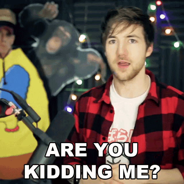 a man stands in front of a microphone and says " are you kidding me "