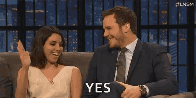 Two guests at a late-night desk exchange a high five, captioned “YES.”