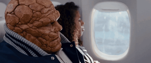 a man with a stone face is sitting next to a woman