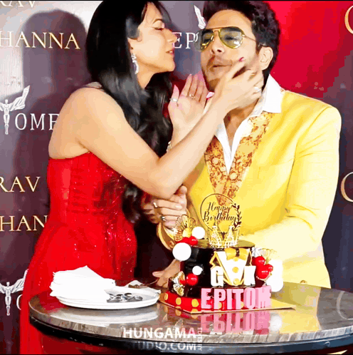 a woman kisses a man on the cheek in front of a cake that says epitom on it