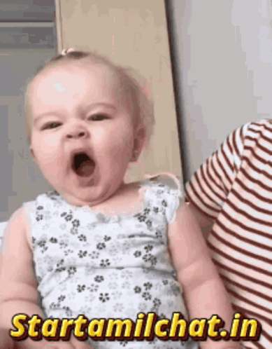 A baby opens their mouth in a sleepy yawn.
