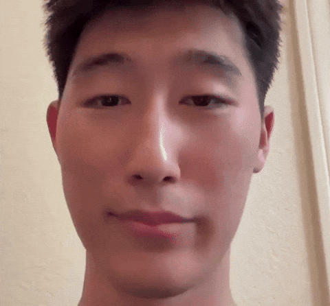 A person in a selfie video looks into the camera with a subtle expression.