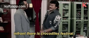 two men are standing next to each other in a room and one of them is talking about crocodiles festival .