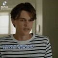 a young man in a striped shirt is standing in a kitchen .