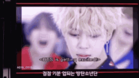 a blurred image of a man and two women with the words bts is getting excited