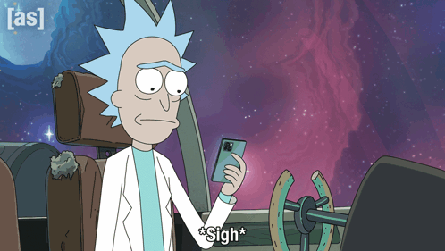 Rick from Rick and Morty sighs while looking at his phone in a spaceship.