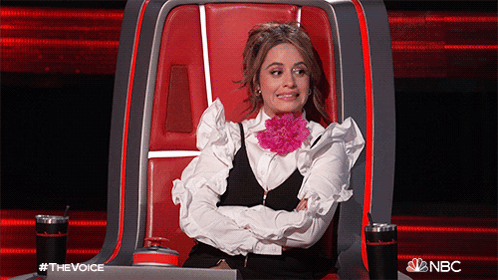 a woman is sitting in a chair with her arms crossed and a flower in her mouth ..