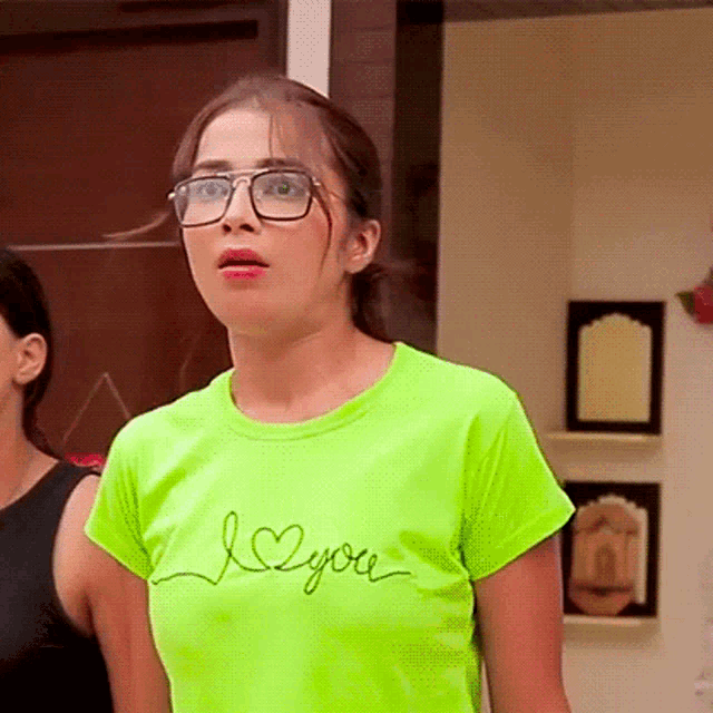 a woman wearing glasses and a neon green i love you shirt