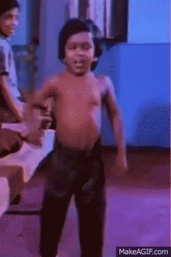 A shirtless man dances energetically in a party scene.
