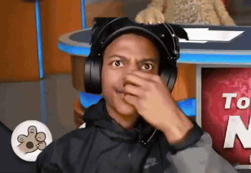A headset-wearing streamer covers his mouth in stunned silence.
