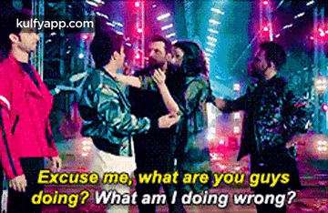 a group of men are standing next to each other in a dark room and talking to each other .