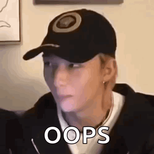 a man wearing a baseball cap is making a funny face and saying oops .