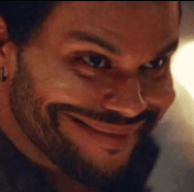 a man with a beard is smiling and looking at the camera