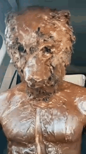 a statue of a man with a bear 's head on his chest covered in chocolate .