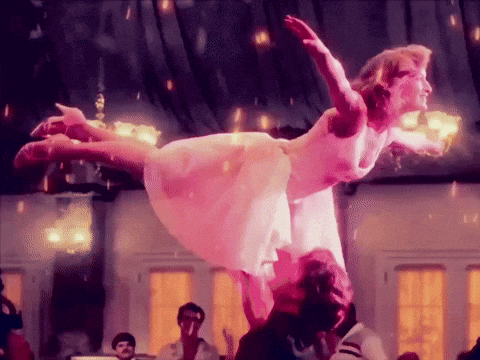 a woman in a pink dress is being lifted in the air