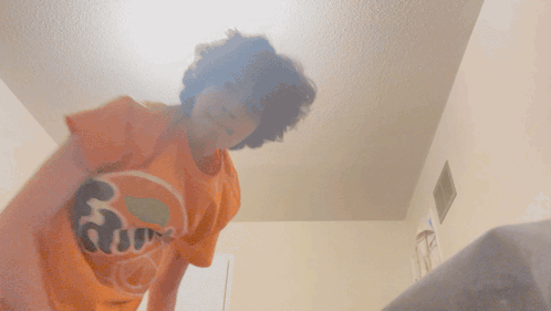 a person in an orange fanta shirt is dancing