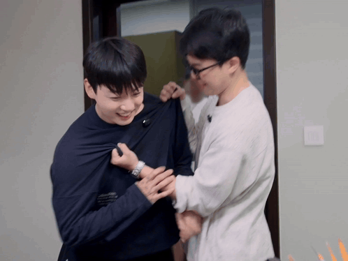 two men are standing next to each other and one has a watch on
