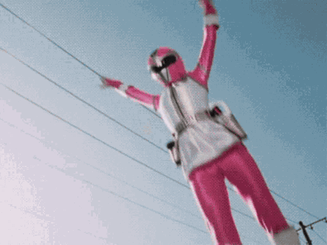 a woman in a pink superhero costume is hanging from a power line