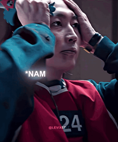 Nam-gyu from Squid Game holds his head in nervous disbelief.