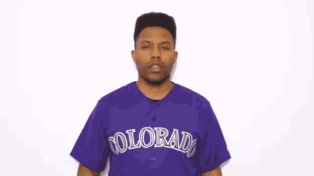 a man wearing a purple colorado jersey covers his face with his hand