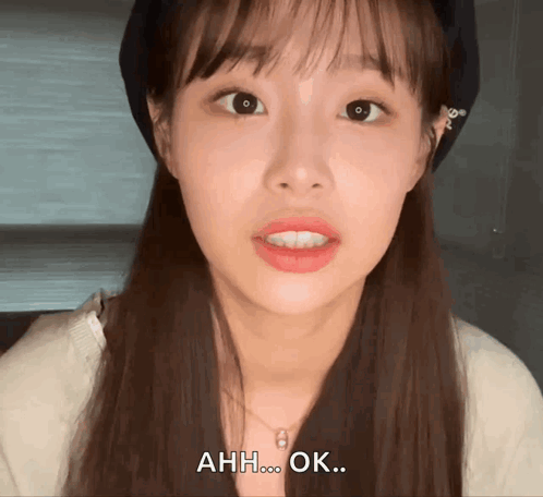 A woman looks into the camera with a confused, hesitant expression.