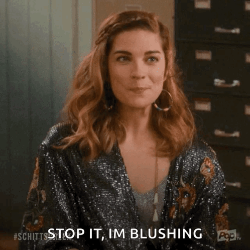 Alexis Rose gives a modest smile with the caption “Stop it, I’m blushing.”