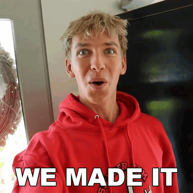 a man wearing a red hoodie with the words we made it