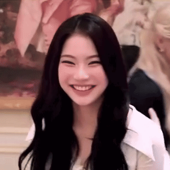 a woman with long black hair is smiling and looking at the camera .