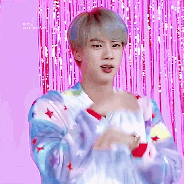 a close up of a person in front of a pink background