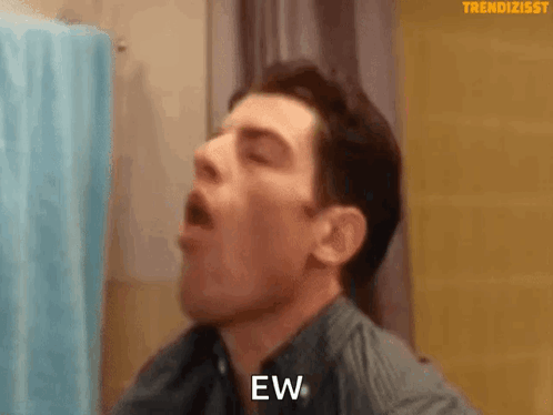A man leans back with his mouth open as if dry heaving.