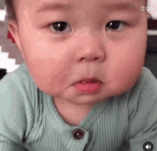 A baby looks teary-eyed toward the camera in a close-up reaction clip.