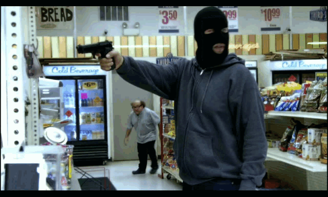 a man holding a gun in front of a bread sign