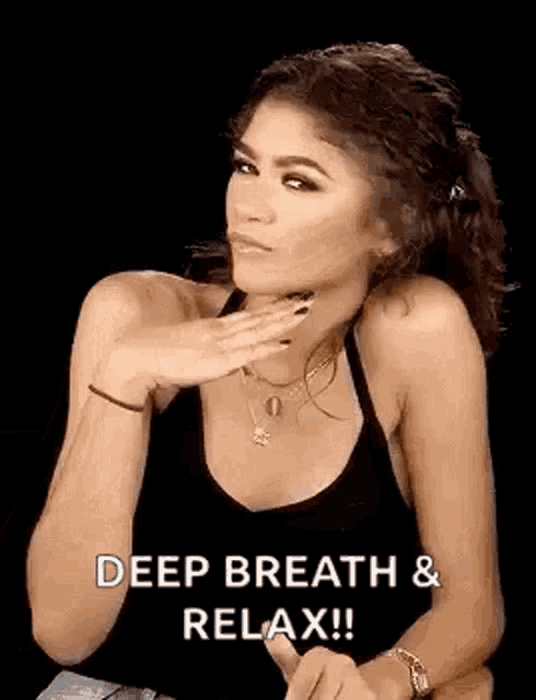 Zendaya holds up a calming hand gesture with “DEEP BREATH & RELAX!!” text.