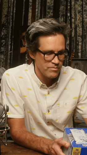 a man wearing glasses is holding a box of 16 value pack