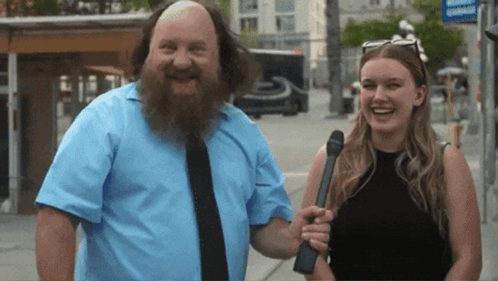 a man with a beard is smiling next to a woman