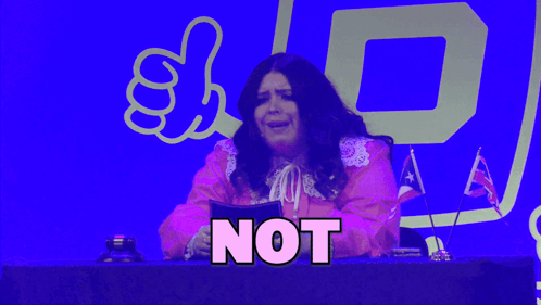 a woman in a pink dress is sitting at a desk with the word guilty on it