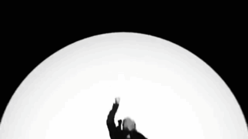 a black and white photo of a man in a suit with his hands in the air