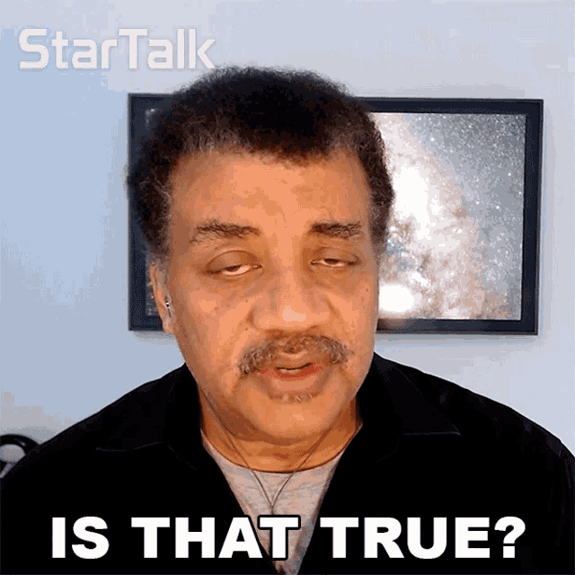 a man with a mustache says " is that true " in front of a picture of a galaxy