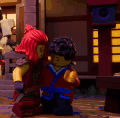 a couple of lego figures standing next to each other in front of a building