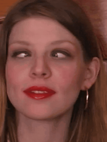 a close up of a woman 's face with red lipstick on .