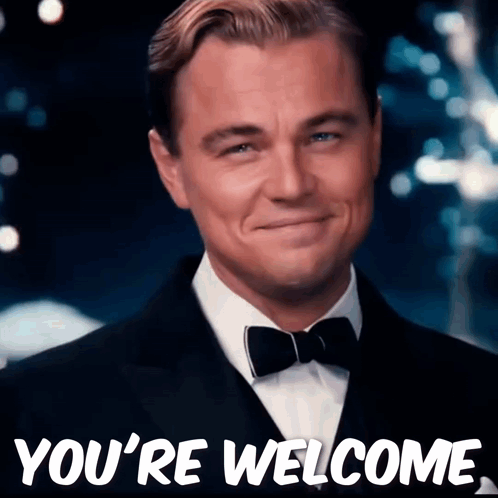 Leonardo DiCaprio smiles in a black tuxedo at a formal event.